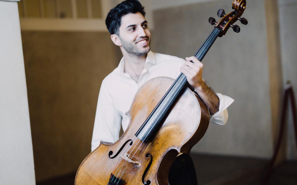 Kian Soltani holding a cello