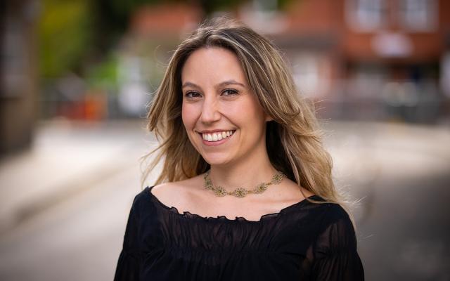 Clara Gatti Comini, Philharmonia Instrumental Fellow, smiling at the camera outside Philharmonia office