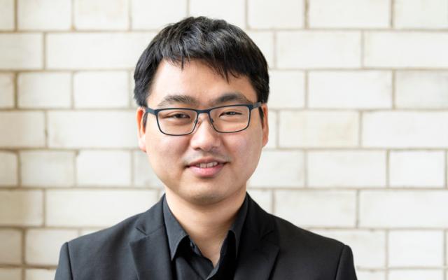Violist Daichi Yoshimura in black suit smiling.