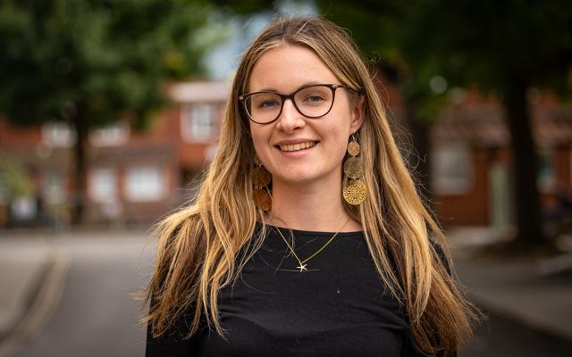 Daisy Noton, Philharmonia Instrumental Fellow, smiling at the camera outside Philharmonia offices