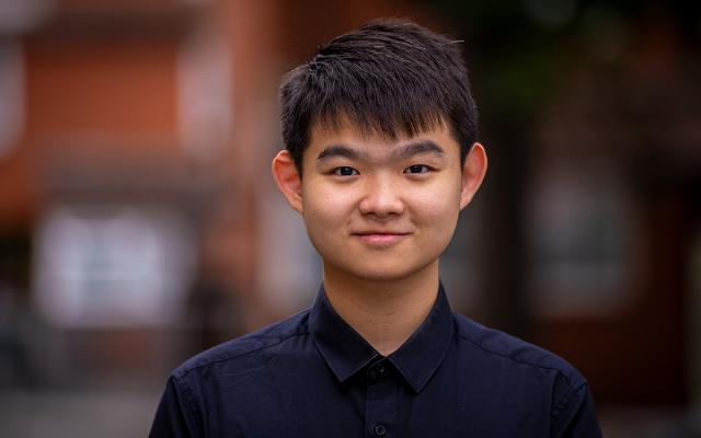 Guozhi Long, Philharmonia Instrumental Fellow, smiling at the camera outside Philharmonia office