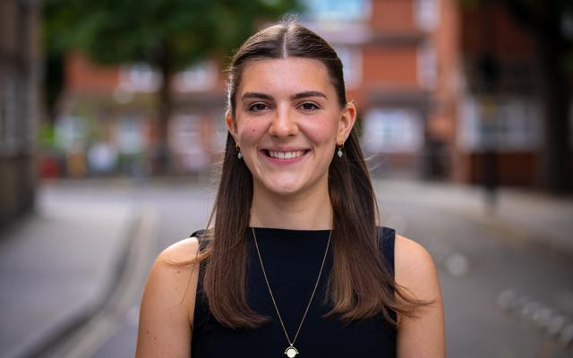 Imogen Timmins, Philharmonia Instrumental Fellow, smiling at the camera outside Philharmonia office