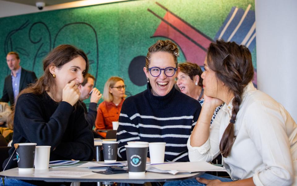 Three women in discussion sitting at a table