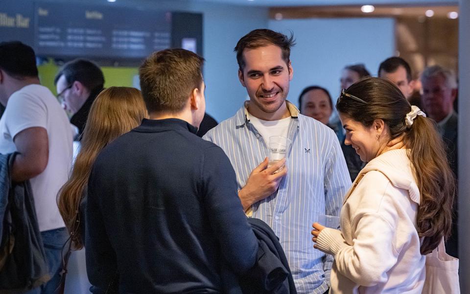 A group of people speaking to each other in a bar area of the Royal Festival Hall